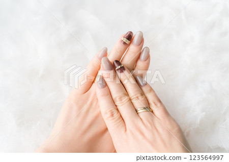 Nail salon - woman doing gel nails (beige, brown, autumn/winter design) 123564997