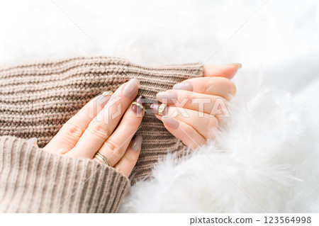 Nail salon - woman doing gel nails (beige, brown, autumn/winter design) 123564998