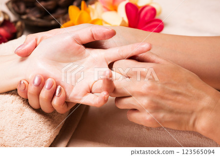 A young Asian woman is getting a hand massage. 123565094