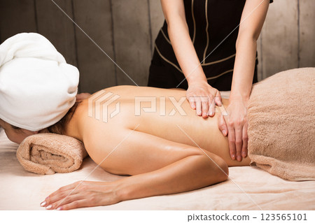 一位年輕的亞洲女性正在接受背部精油按摩。 123565101