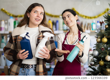 Woman seller offers cleaning spray to young woman buyer 123566109