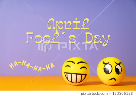 April Fool's Day, yellow balls with faces on a purple background with text 123566158
