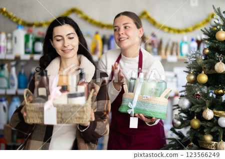 seller offers a woman a bath milking set against the background of a Christmas tree 123566249