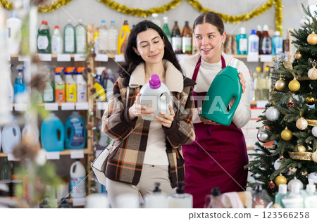 Young saleswoman offering detergent to girl 123566258