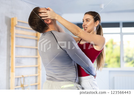 Adult man and young woman training self-defense techniques 123566443