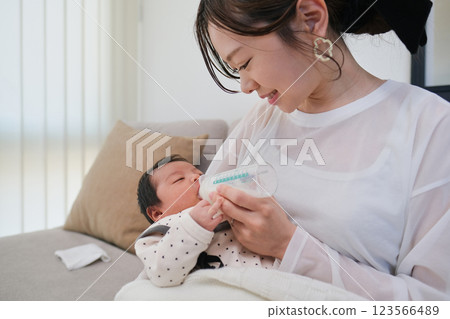 Mother feeding newborn baby with a bottle 123566489