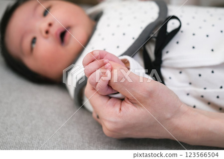 Close-up of newborn baby's hand holding mother's hand 123566504