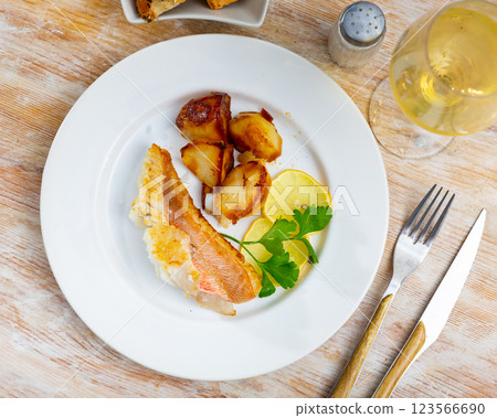 Tasty Gallineta fish fillet with sliced potatoes, served on dinner table 123566690