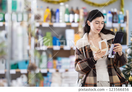 Young girl choosing comb in store with New Year decoration 123566856