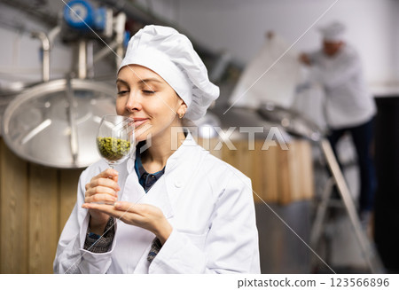 Female brewer smelling hops pellets 123566896