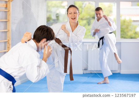Woman and man in kimono sparring together in sport gym during karate training 123567197