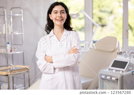 Woman beautician wearing overall posing in clinic of esthetic medicine Woman beautician wearing overall posing in clinic of esthetic medicine 123567280