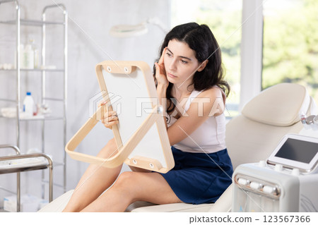 woman gazes at herself in mirror woman gazes at herself in mirror 123567366