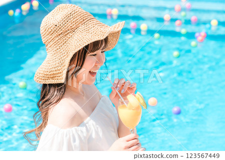 Young Asian woman drinking tropical juice by the pool (resort vacation) Young Asian woman drinking tropical juice by the pool (resort vacation) 123567449