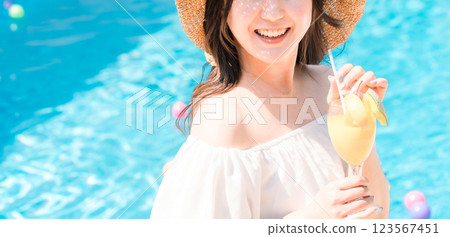 年輕的亞洲女性在泳池邊喝熱帶果汁（度假村/假期/假期） 123567451