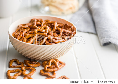 Heart shaped pretzel in bowl on white table. Heart shaped pretzel in bowl on white table. 123567694