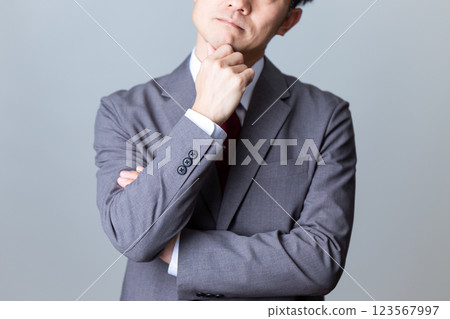 一位身穿灰色西裝的中年男性商人思考 一位身穿灰色西裝的中年男性商人思考 123567997