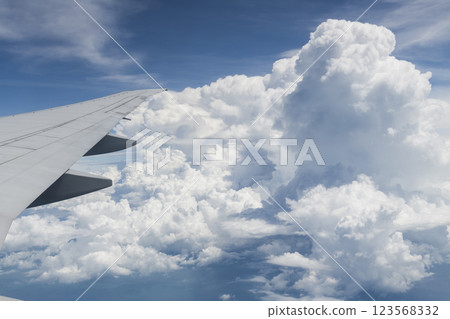 View of the plane's wing and beautiful clouds through the window during the flight. 123568332