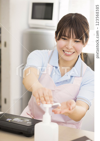 一位女性護理人員在吃飯前用酒精消毒午餐盒 123568385
