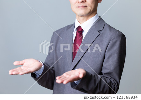 A middle-aged male businessman in a suit spreading his palms A middle-aged male businessman in a suit spreading his palms 123568934