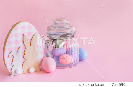 Easter concept, wooden bunny figurine and easter eggs on pink background with copy space 123569061