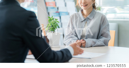 Female customer listening to a salesperson at a business meeting table 123570555