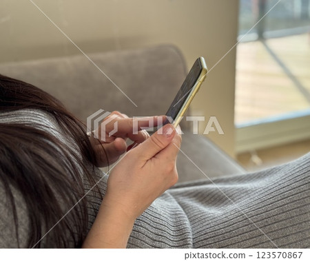 young girl with smartphone in hand at home 123570867