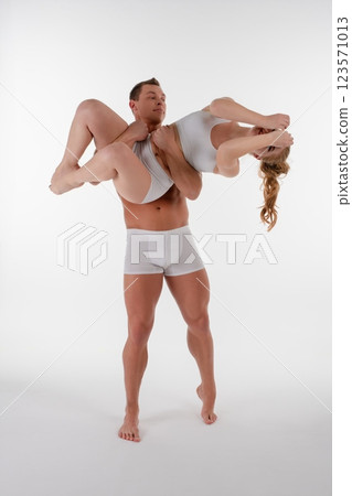 Couple engaged in dynamic sports pose showcasing strength and balance 123571013