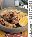 Seafood dish featuring crispy calamari served with a fresh lemon wedge on a rustic wooden table 123571343