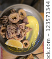 Crispy calamari served with lemon and a vibrant sauce in a cozy restaurant setting 123571344