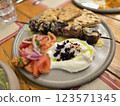 Delicious grilled kebab served with fresh salad and flatbread on a rustic wooden table 123571345