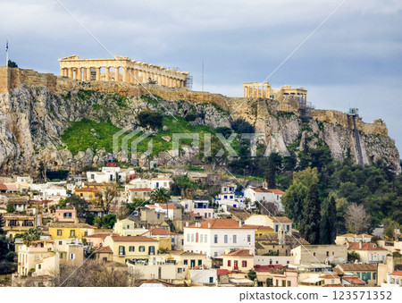 View of the Acropolis and Athens with traditional houses under a cloudy sky View of the Acropolis and Athens with traditional houses under a cloudy sky 123571352