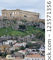 Acropolis of Athens stands majestically above modern buildings and green hills 123571356