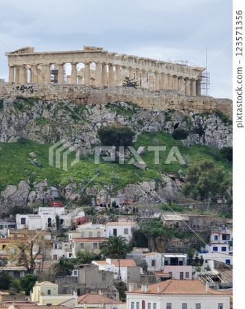 Acropolis of Athens stands majestically above modern buildings and green hills Acropolis of Athens stands majestically above modern buildings and green hills 123571356