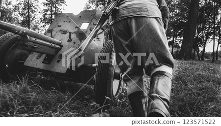 Group Of Re-enactors Dressed As Russian Soviet Red Army Infantry Soldiers Of World War Ii Are Move Soviet 45mm Anti-tank Gun To Preparing Combat Position. Black And White Video 123571522