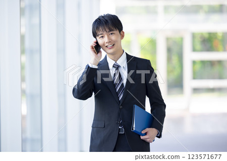 商業:年輕人在智慧型手機上交談 商業:年輕人在智慧型手機上交談 123571677