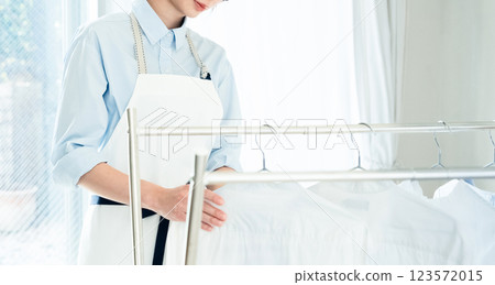 A woman drying clothes in a room A woman drying clothes in a room 123572015