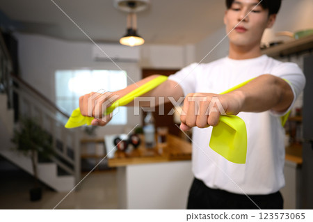 Young man stretching the band to work on his upper body strength 123573065