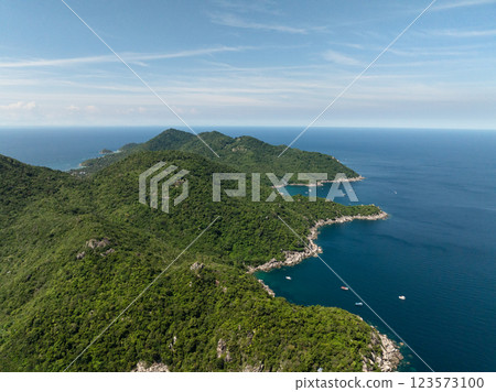 Expansive view of the coastline featuring forested hills and the deep blue sea under a clear sky. Koh Tao, Thailand. 123573100