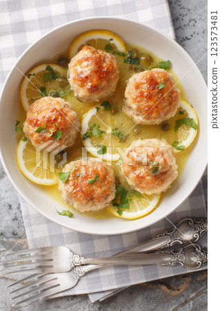 Chicken Piccata Meatballs Deliciously made with lemon zest, garlic, and a caper sauce closeup in the plate. Vertical top view Chicken Piccata Meatballs Deliciously made with lemon zest, garlic, and a caper sauce closeup in the plate. Vertical top view 123573481