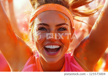 Young woman cheers joyfully after marathon finish in vibrant outdoor celebration 123573804