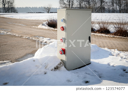 Industrial Outdoor Electrical Power Distribution Box with Multiple Plugs in a Winter Landscape 123574077