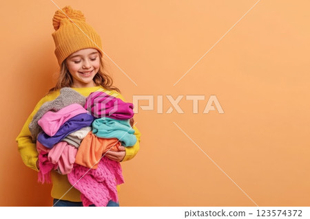 Young woman organizes warm clothing donations for winter shelter in a bright setting 123574372