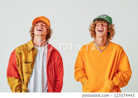 Young man laughs nervously as friend executes a playful prank in fun setting 123574443