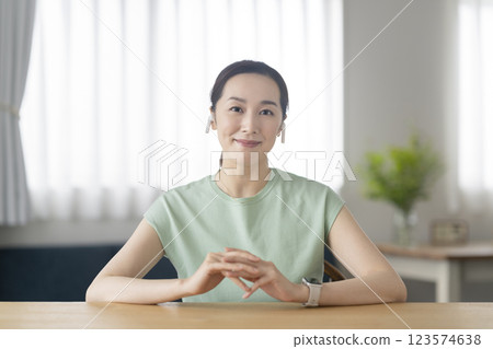 一名 30 多歲女性戴著耳機看著鏡頭 123574638