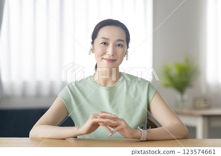 一名 30 多歲的女性戴著耳機，對著鏡頭微笑 123574661