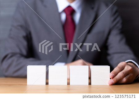 四塊白色木塊和穿著西裝的中年男性商人 123575171