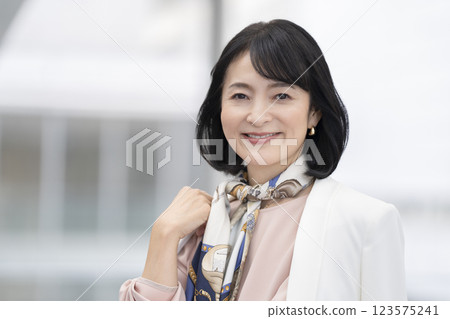 一個 50 多歲的女人對著鏡頭微笑的肖像 123575241