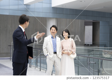Salesman and a couple in their 50s viewing a property 123575317