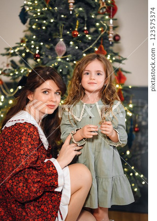 Beautiful mother and daughter at the Christmas tree.  123575374
